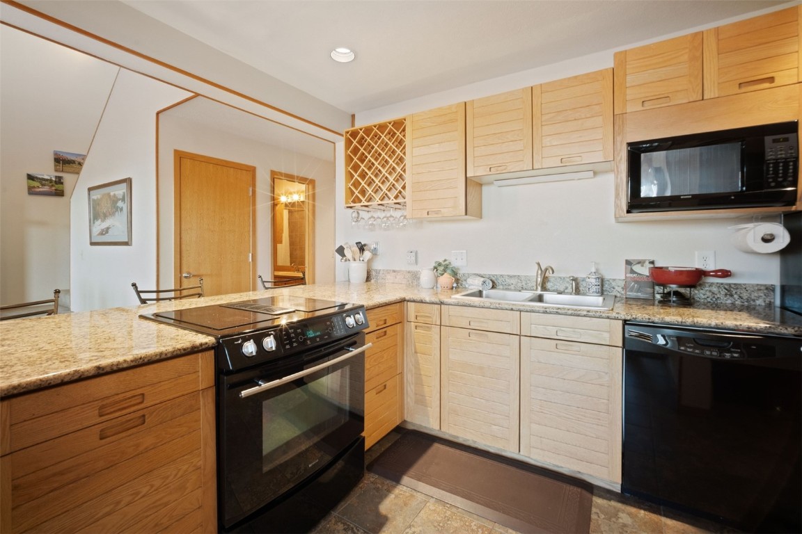 91400 Ryan Gulch Road, Unit 91425 Silverthorne, CO 80498 - Photo 11 of 42 a kitchen with stainless steel appliances granite countertop a stove a sink and a microwave