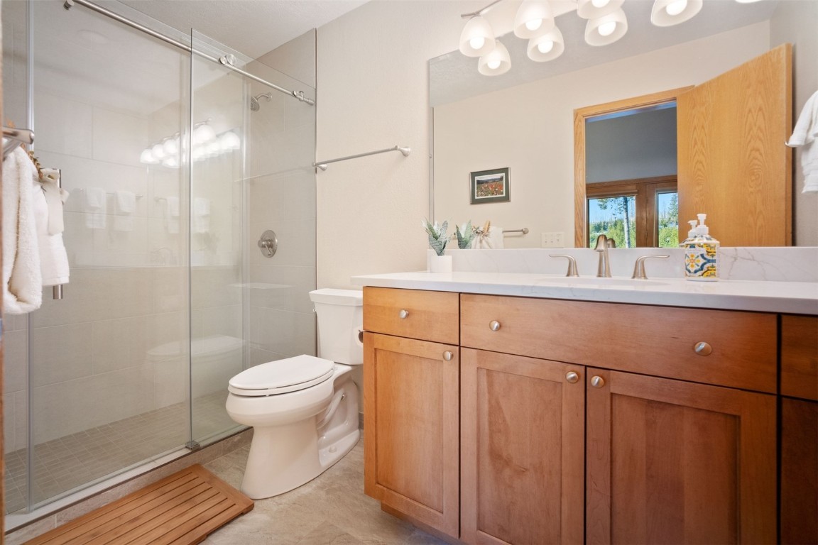 91400 Ryan Gulch Road, Unit 91425 Silverthorne, CO 80498 - Photo 15 of 42 a bathroom with a sink toilet a mirror and shower