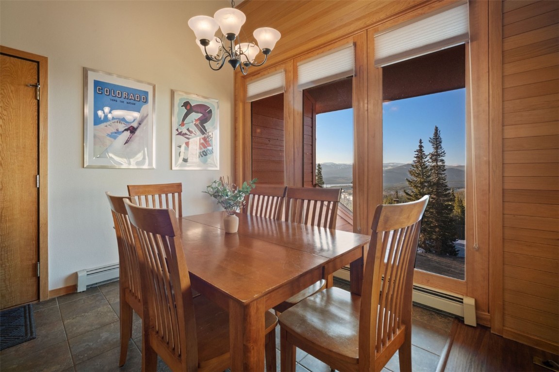 91400 Ryan Gulch Road, Unit 91425 Silverthorne, CO 80498 - Photo 25 of 42 a view of a dining room with furniture wooden floor and a chandelier