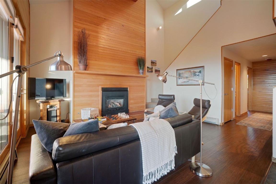 91400 Ryan Gulch Road, Unit 91425 Silverthorne, CO 80498 - Photo 6 of 42 a living room with furniture a fireplace and wooden floor