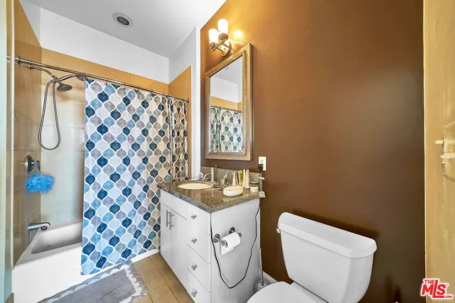a bathroom with a granite countertop sink a shower and a mirror