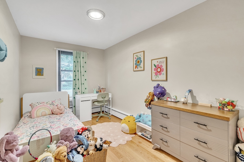 32 Juniper Street, Unit 91 Brookline, MA 02445 - Photo 12 of 21 a bedroom with a bed and wooden floor