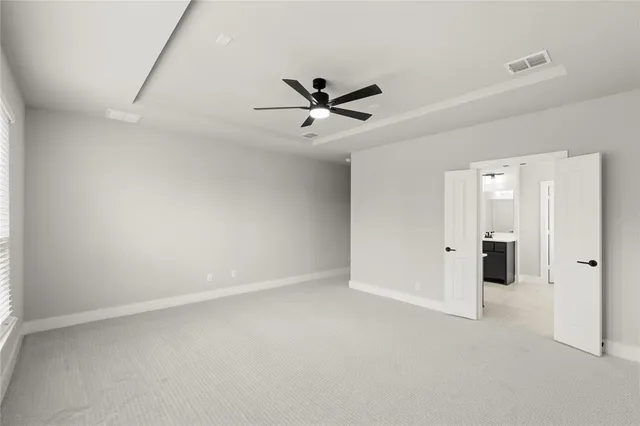 an empty room with closet and a ceiling fan