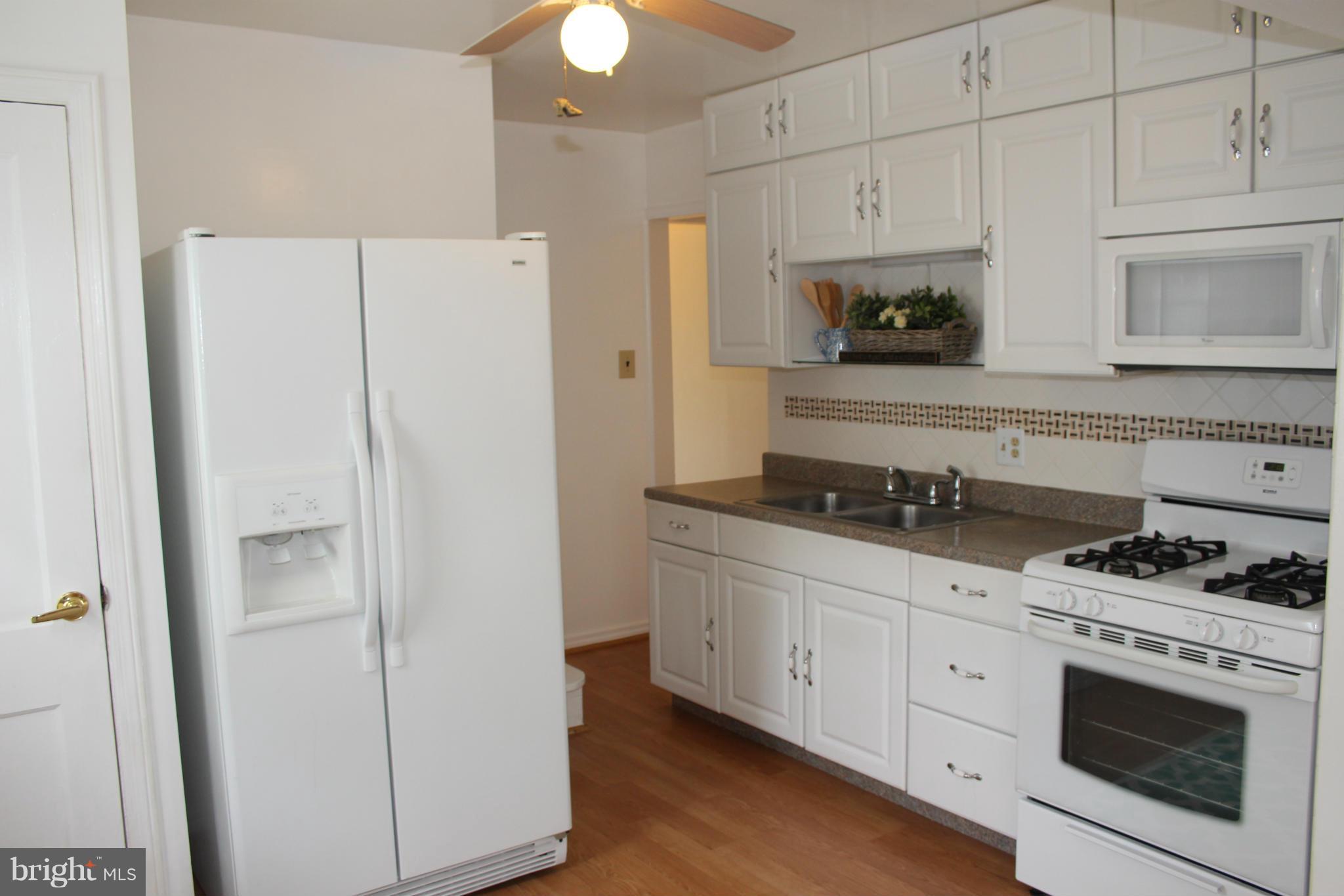 4214 Garrett Park Road Silver Spring, MD 20906 - Photo 11 of 22 a kitchen with stainless steel appliances white cabinets and a refrigerator