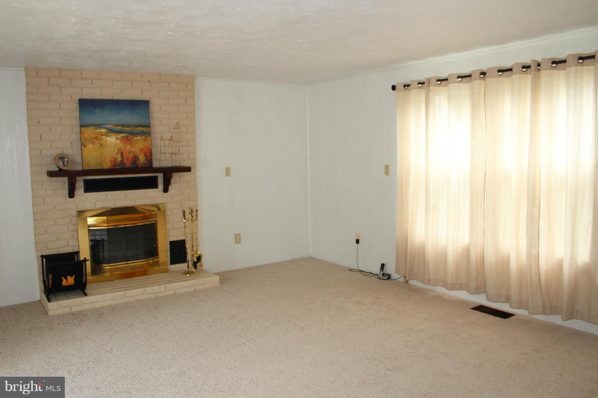 4214 Garrett Park Road Silver Spring, MD 20906 - Photo 14 of 22 a view of an empty room with a fireplace and a window
