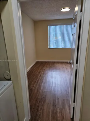 a view of a room with wooden floor and a window
