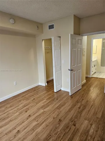 a view of empty room with wooden floor and window