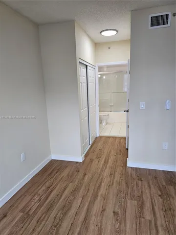 a view of a room with wooden floor and electronic appliances