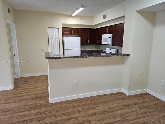 a view of kitchen with microwave and cabinets