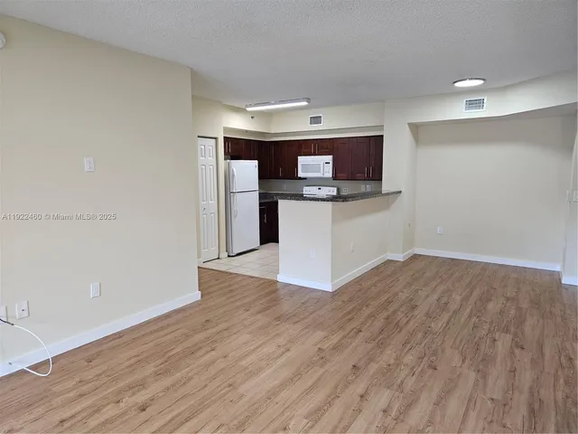 a kitchen with a wooden floor and white appliances