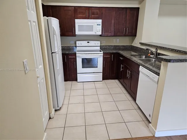 a kitchen with a refrigerator sink and cabinets