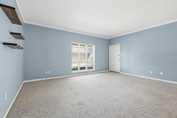 a view of an empty room with closet and stairs
