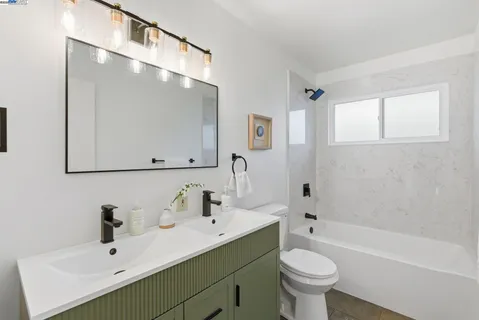 a bathroom with a sink mirror toilet and bathtub