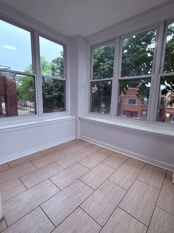 a view of empty room with floor to ceiling windows and yard