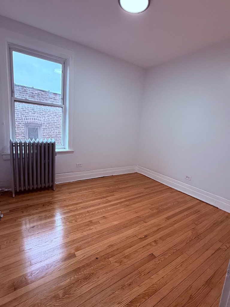 6928 South Green Street, Unit 2N Chicago, IL 60621 - Photo 9 of 11 a view of an empty room with wooden floor and a window