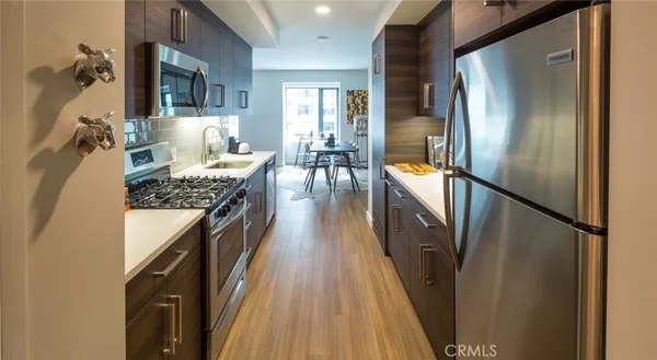 a kitchen with kitchen island granite countertop a refrigerator a stove and a sink