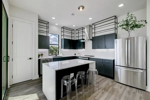 a kitchen with stainless steel appliances a sink dishwasher a stove and a microwave oven