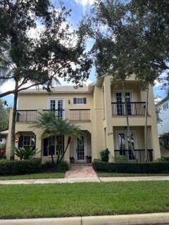 a front view of a house with a yard and potted plants