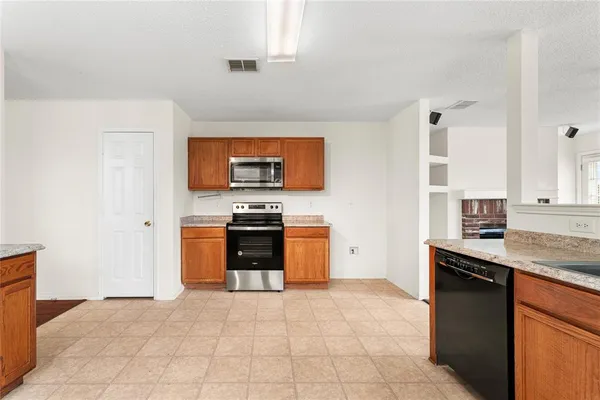 a kitchen with stainless steel appliances granite countertop a stove a sink and a refrigerator