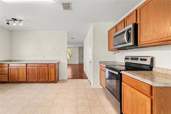 a kitchen with stainless steel appliances granite countertop a stove top oven a sink dishwasher and a microwave oven on the blue kitchen countertops