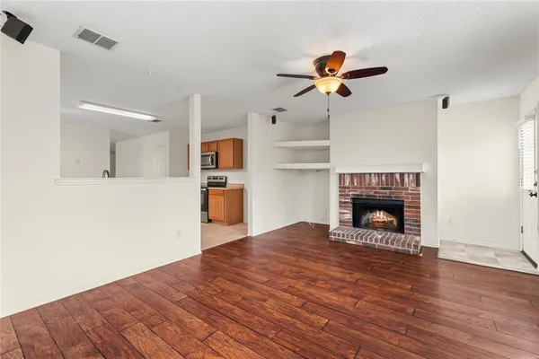 a view of empty room with wooden floor and fireplace