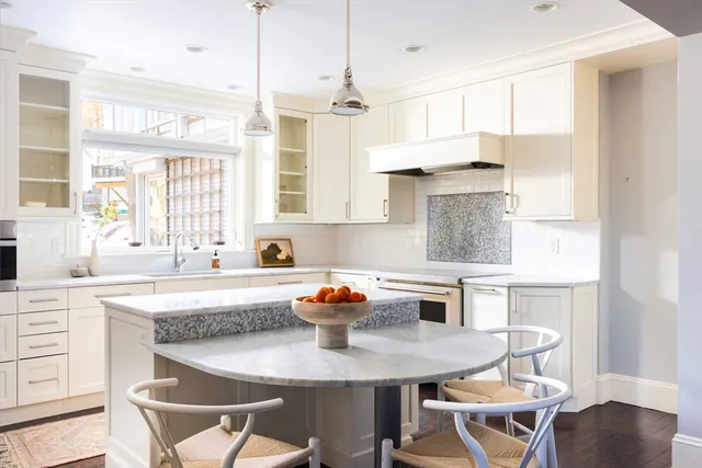 a kitchen with a table chairs a sink dishwasher window and cabinets