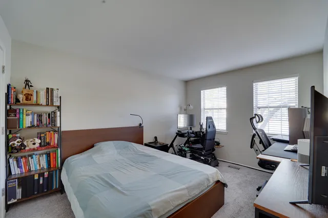 a bedroom with a bed a large bookshelf and a window