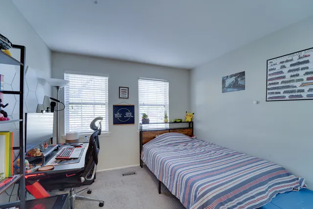 a bedroom with a bed and a computer on the desk