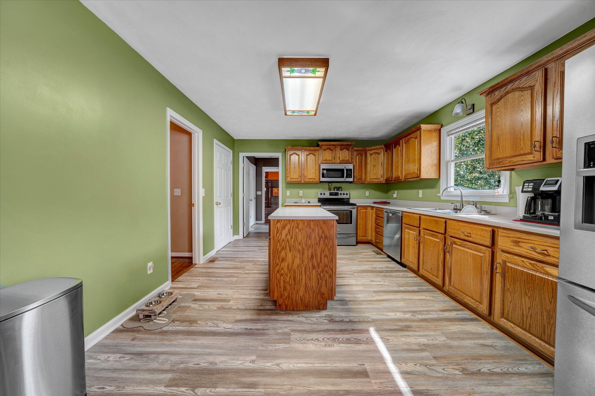 1041 Owen Ridge Lane Goodview, VA 24095 - Photo 21 of 58 a large kitchen with stainless steel appliances granite countertop a refrigerator a stove top oven a sink dishwasher and wooden cabinets