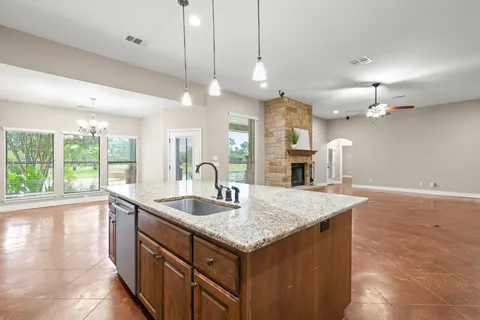 a view of an empty room and kitchen view