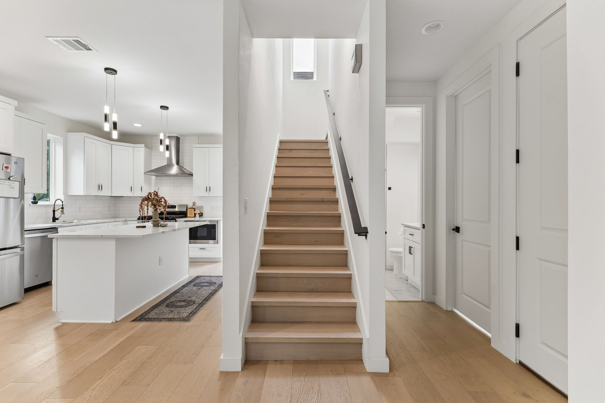 5305 Ledesma Road, Unit 1 Austin, TX 78721 - Photo 12 of 26 A view of the staircase, featuring modern metal railings and light wood treads. The design is open and sculptural, contributing to the home's contemporary architectural feel.
