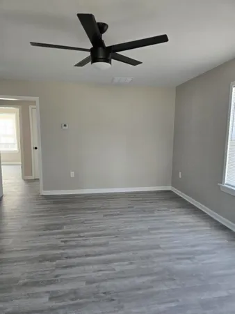 a view of a room with wooden floor and white walls