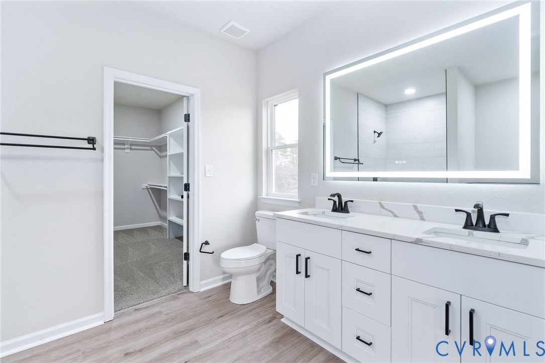63 Hatcher Road Powhatan, VA 23139 - Photo 31 of 48 a bathroom with a granite countertop toilet sink double vanity and mirror