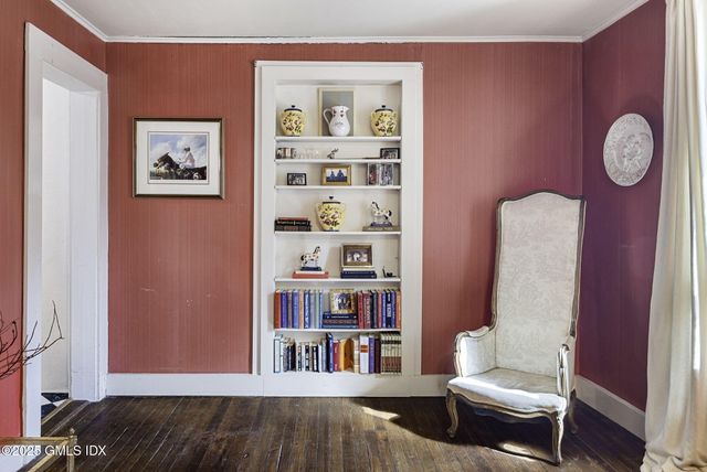 a living room with baby crib and a wooden floor