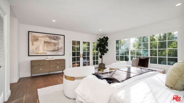 a living room with furniture large window and wooden floor