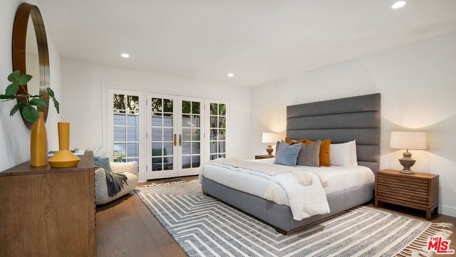 a bedroom with a bed a couch and a potted plant