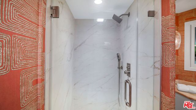 a bathroom with a shower and a glass door