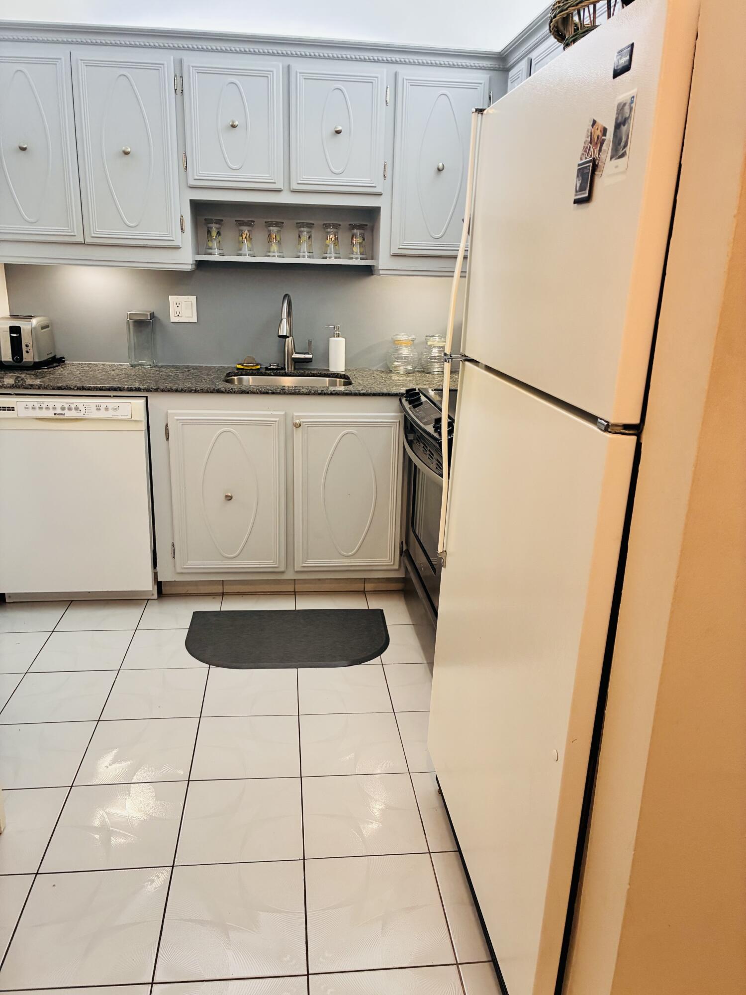 259 South Cypress Road, Unit 533 Pompano Beach, FL 33060 - Photo 9 of 19 a kitchen with a refrigerator a stove a sink and cabinets