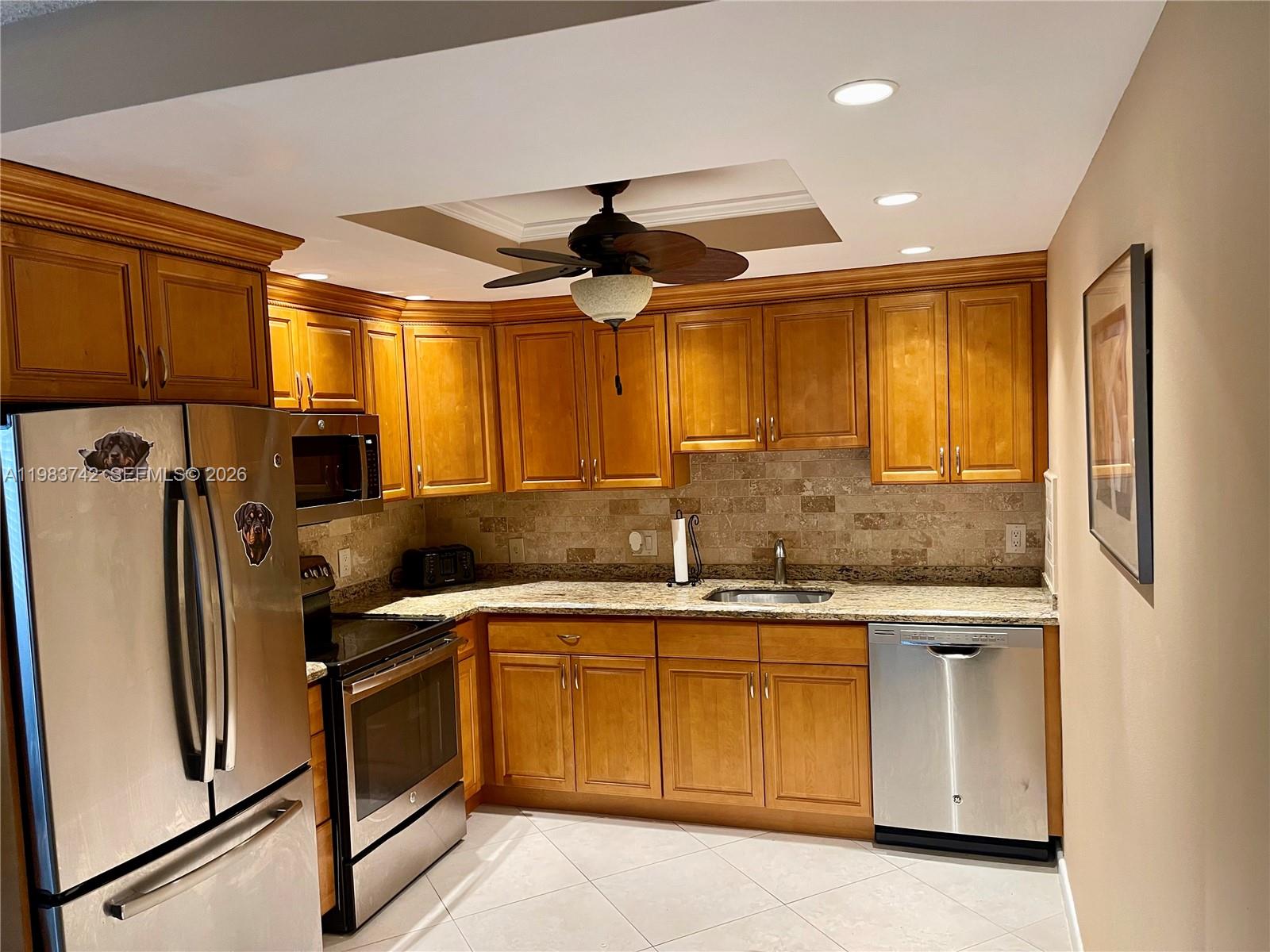 2042 Newcastle A, Unit 2042 Boca Raton, FL 33434 - Photo 4 of 17 a kitchen with a sink stainless steel appliances a counter top space cabinets and a large window
