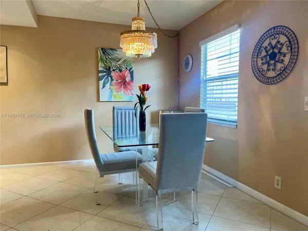 a view of a dining room with furniture and a chandelier