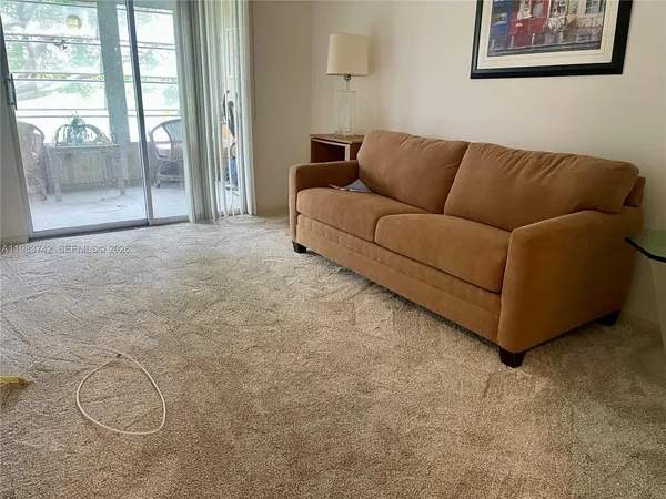 a living room with furniture and a floor to ceiling window