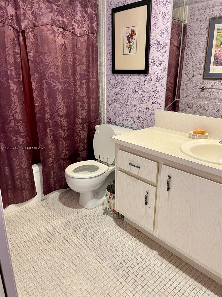 2042 Newcastle A, Unit 2042 Boca Raton, FL 33434 - Photo 10 of 17 a bathroom with a toilet a sink and a mirror
