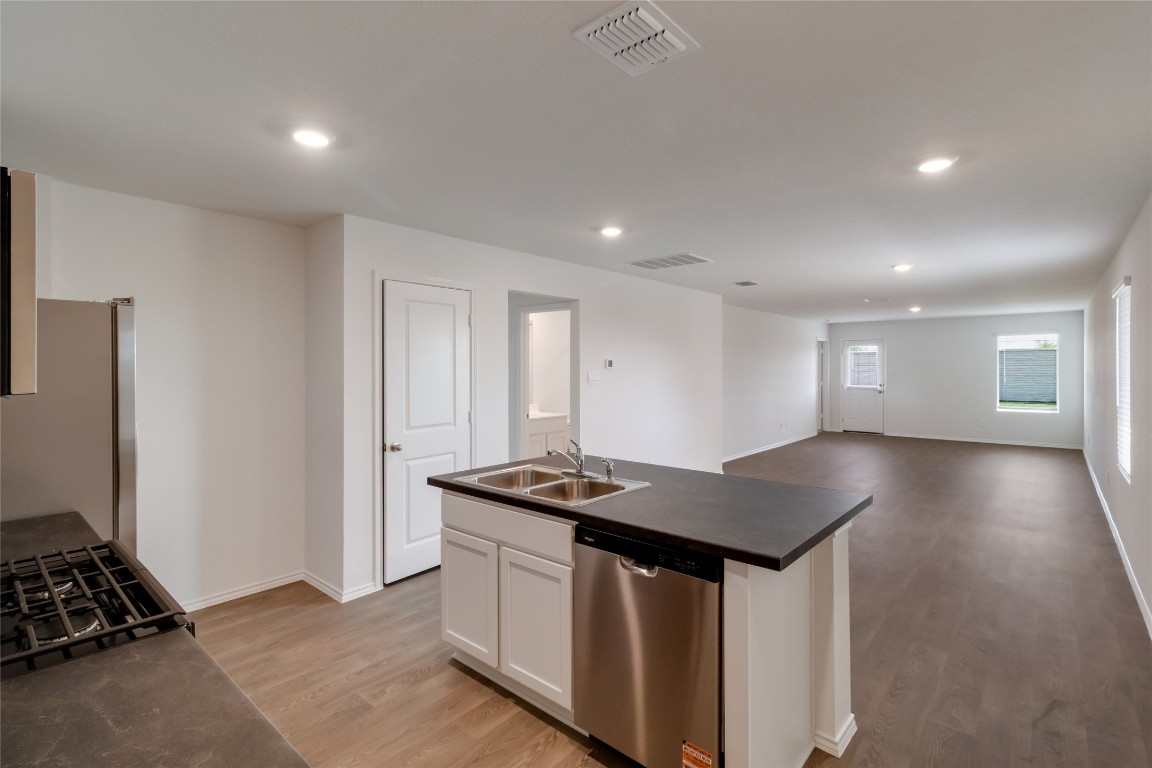 472 Sandringham Loop Kyle, TX 78640 - Photo 6 of 20 a kitchen that has a lot of cabinets a sink and wooden floor