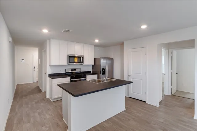 a kitchen that has a lot of cabinets and refrigerator