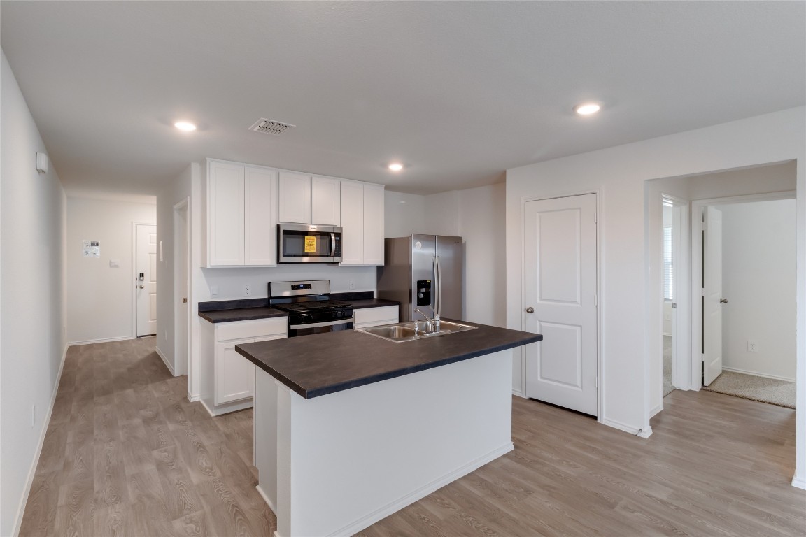 472 Sandringham Loop Kyle, TX 78640 - Photo 7 of 20 a kitchen that has a lot of cabinets and refrigerator