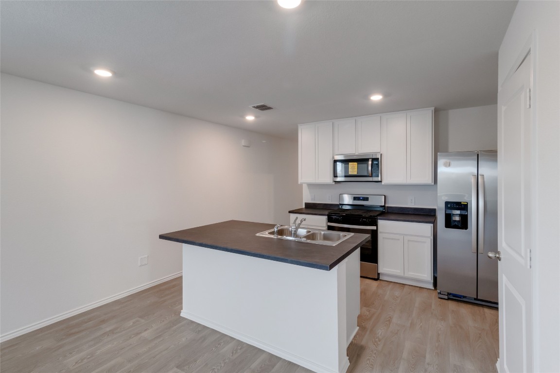 472 Sandringham Loop Kyle, TX 78640 - Photo 8 of 20 a kitchen view with stainless steel appliances granite countertop a stove a refrigerator and a sink