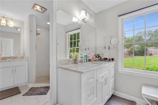 a bathroom with a sink vanity granite tub and shower