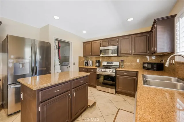 a kitchen with stainless steel appliances granite countertop a refrigerator stove and sink