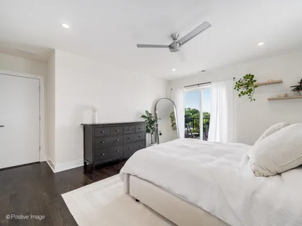a bedroom with a large bed chandelier and a window