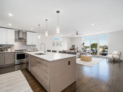a large kitchen with kitchen island a large counter top space a sink and appliances